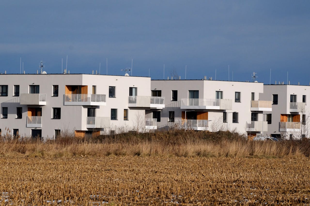 Stylish modern apartment buildings with balconies in a rural setting during daytime.